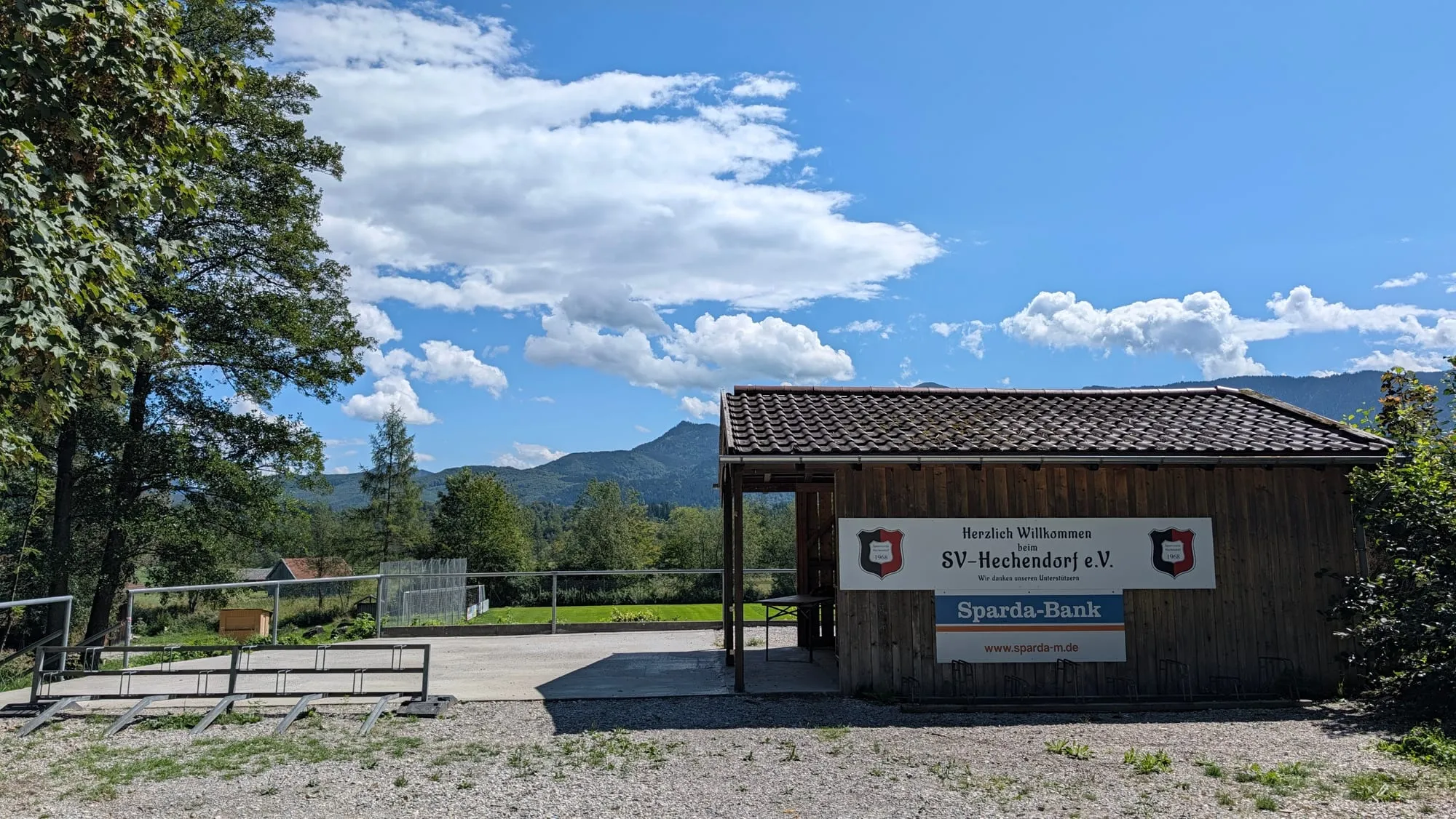Der überdachte Eingang zum Sportheim mit Willkommensschild und Sparda-Bank-Banner