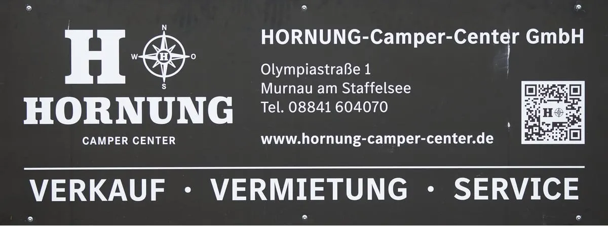 Bandenwerbung des Hornung Camper-Centers in Schwarz-Weiß mit den Worten Verkauf, Vermietung und Service